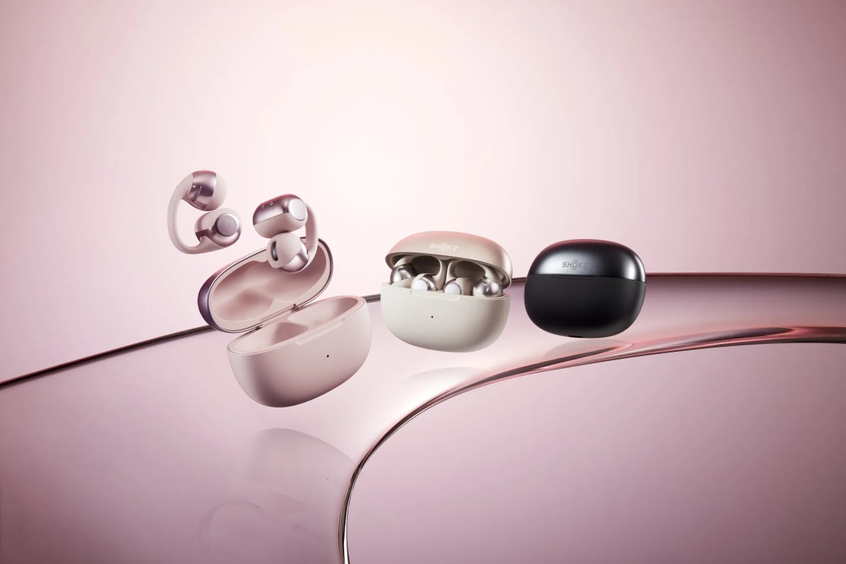 ピンク色の背景に、さまざまなデザインの Shokz のワイヤレスイヤホンが写っています。左には、ケースが開いた状態のイヤホンがいくつかあり、右には、ケースが閉じているイヤホンがいくつかあります。