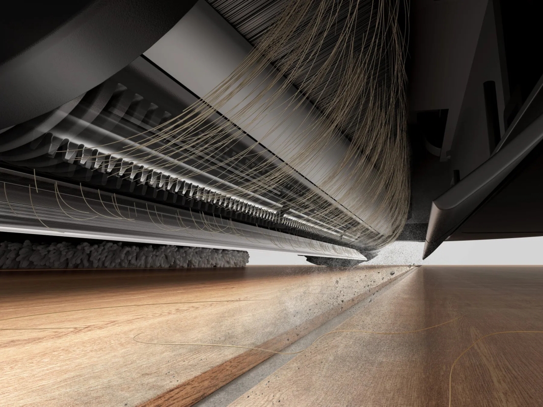 掃除機のブラシ部分のクローズアップ写真。ブラシが床のゴミをかき集めている様子。