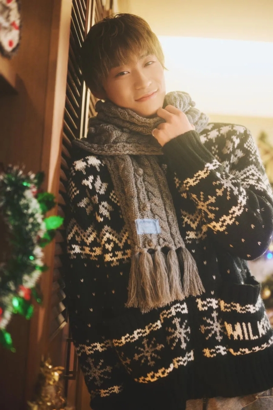 男性が暖かいセーターとスカーフを着て微笑んでいる画像