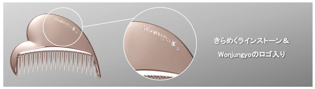 Wonjungyoのロゴとラインストーンがあしらわれた、ピンクゴールドのヘアコームのクローズアップ画像です。コームはハート型をしており、背景はグレーです。