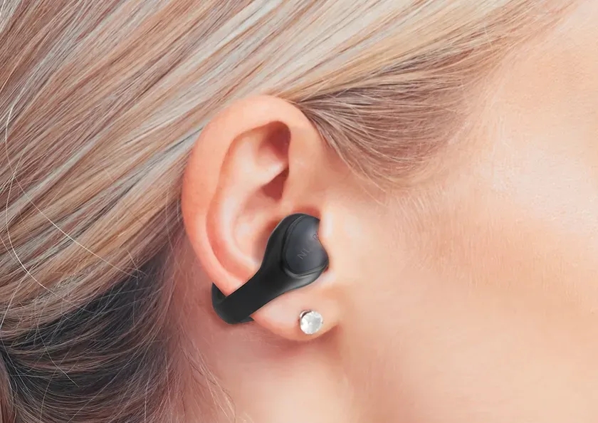 女性の耳に装着された黒いイヤホン