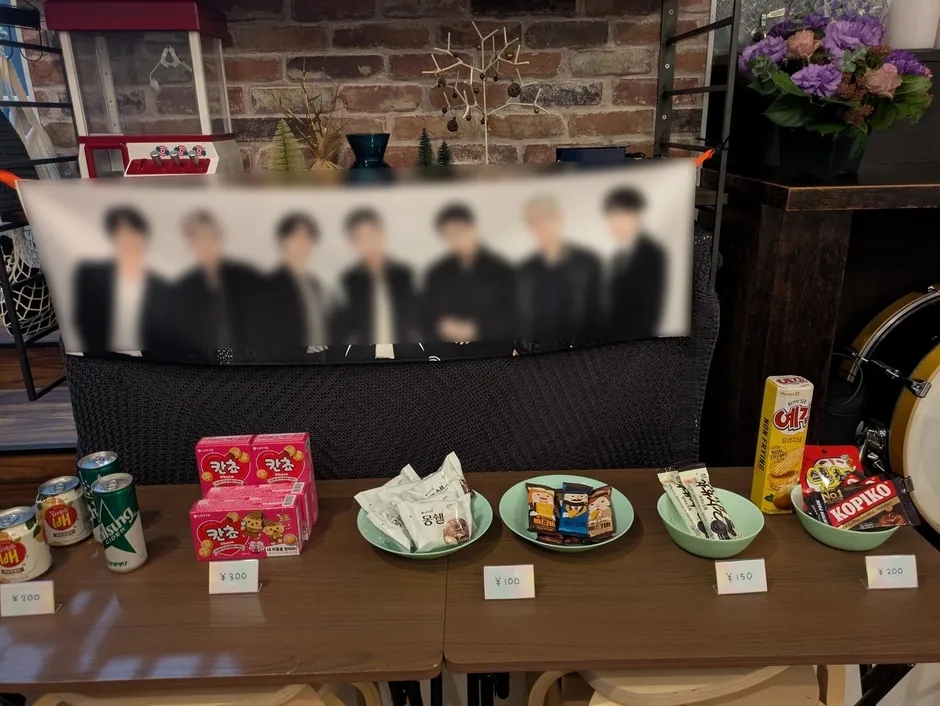 お店のテーブルに並ぶお菓子と飲み物、K-POP写真