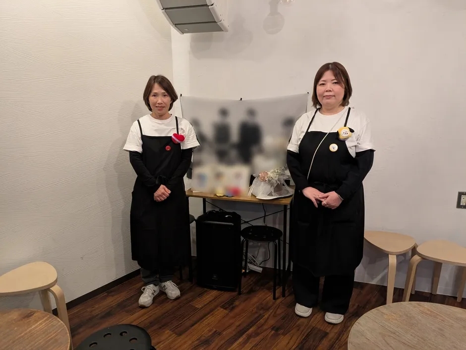 黒いエプロンを着た2人の女性