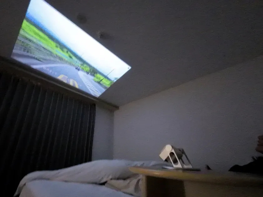 部屋の天井にプロジェクターで映像を投影している様子