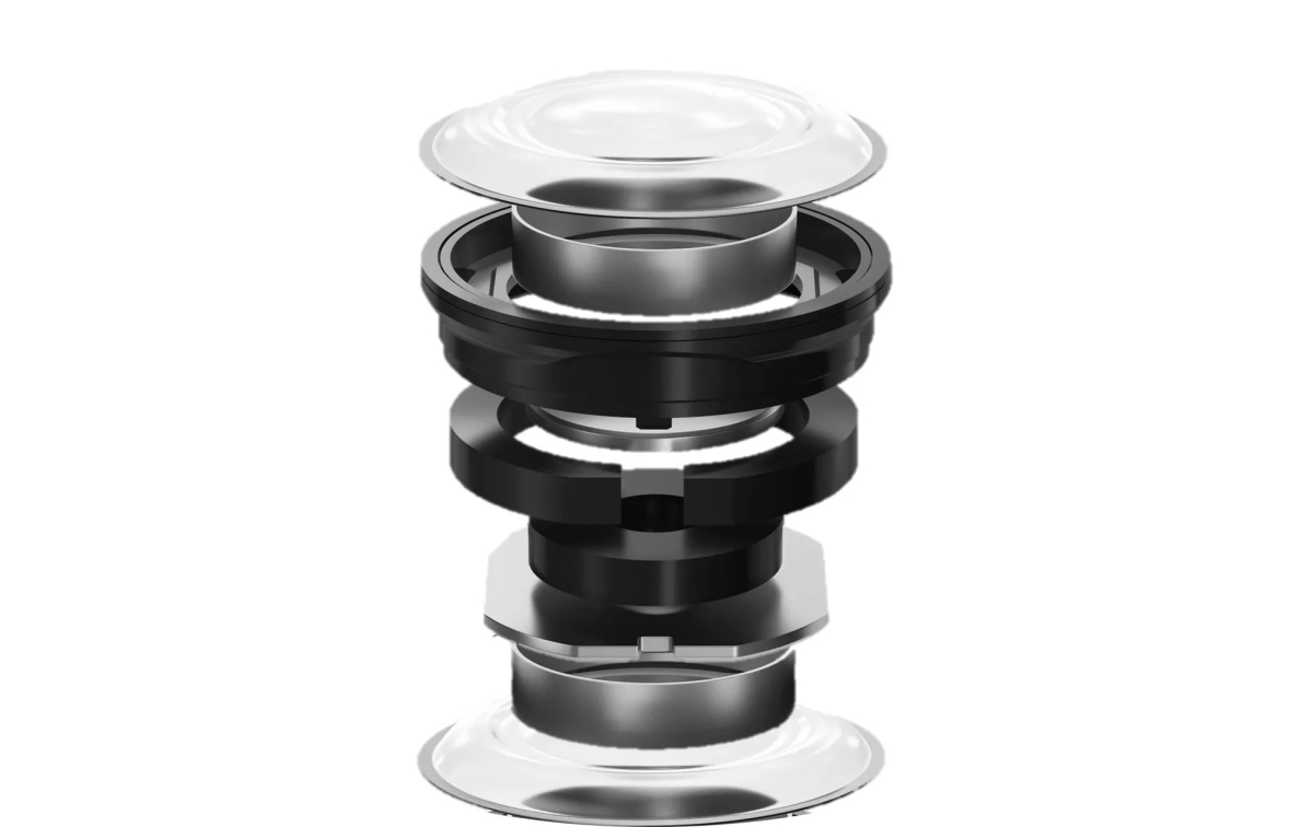 透明なドーム型の部品と、黒と銀色の層状の部品が組み合わさった、分離した部品の画像です。部品は透明なドームから始まり、黒い円形の部分、銀色の円柱、黒いリング、銀色の六角形の部品、そして底部の銀色の円盤で終わっています。