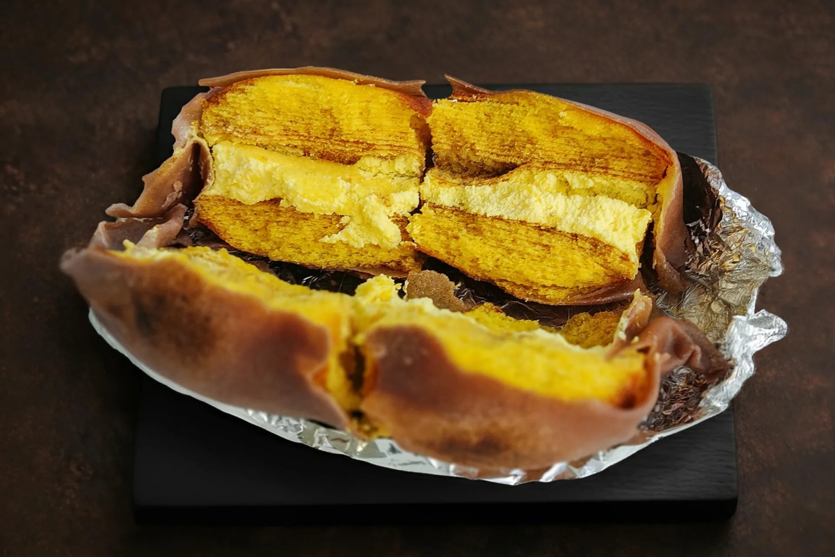 カットされた焼き芋のような食べ物。黄色い部分と茶色い部分があり、アルミホイルの上に載っている。