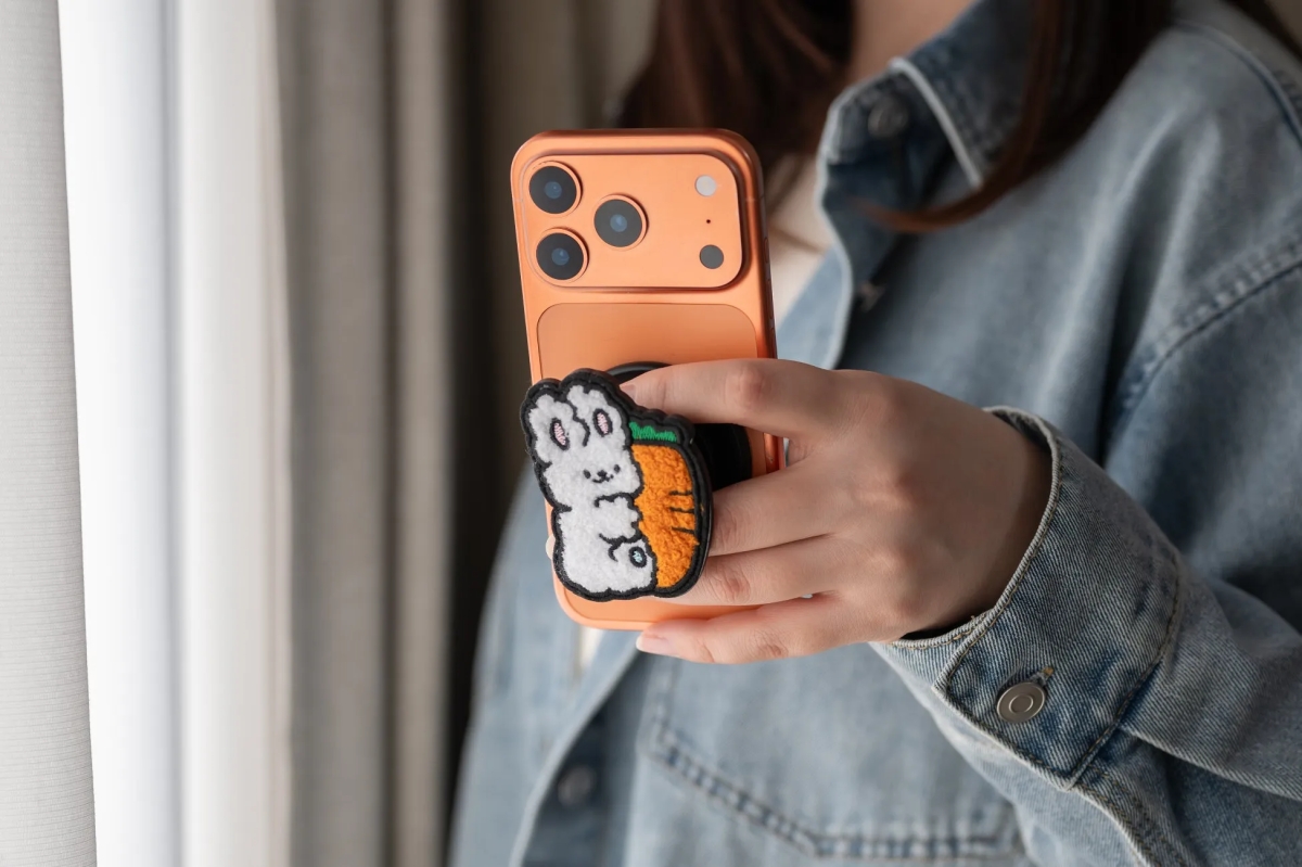 スマホを持った女性。スマホにはウサギとニンジンが描かれたスマホグリップが付いている。