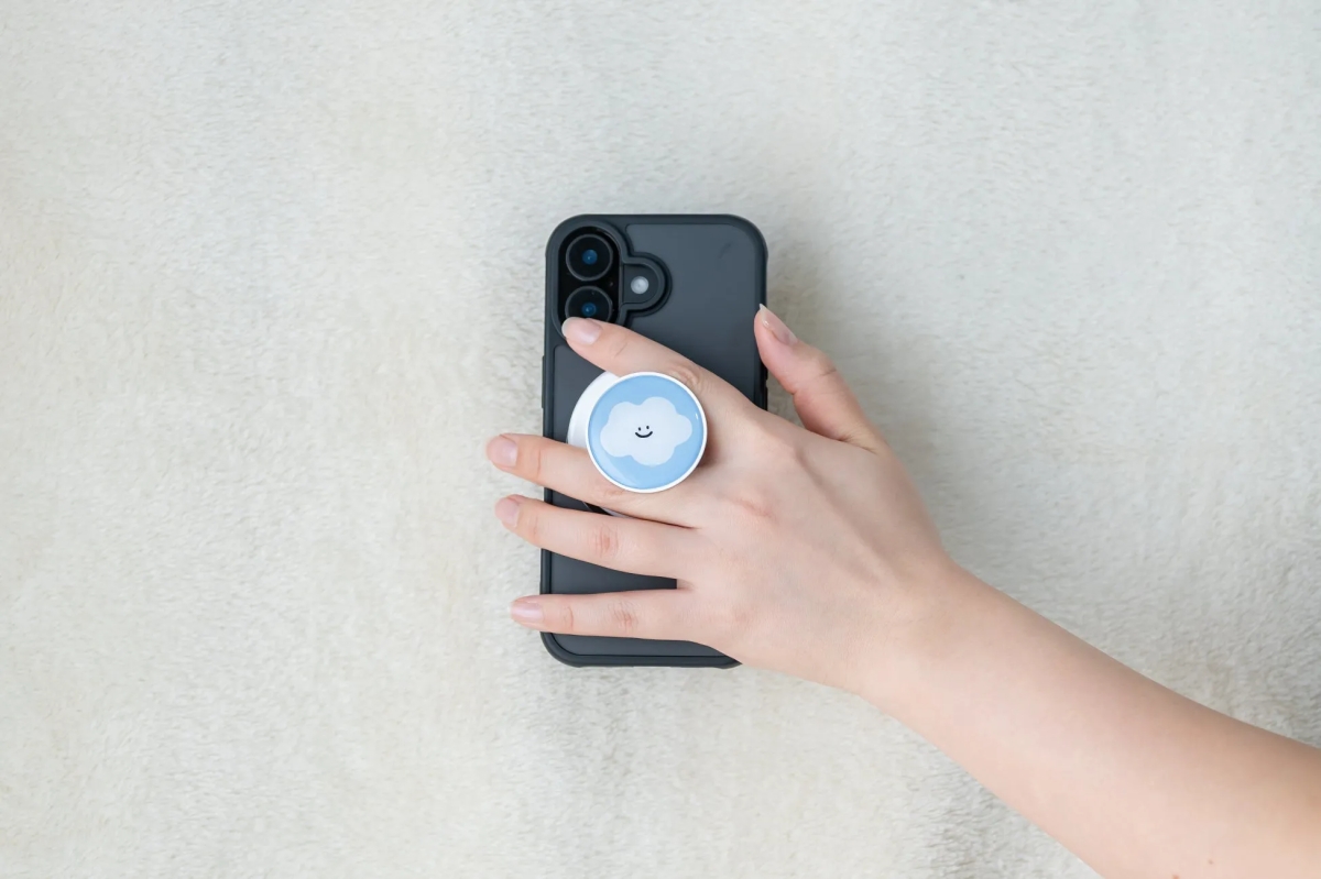 スマホを持った手の写真。スマホには雲の形をしたスマホグリップが付いている。