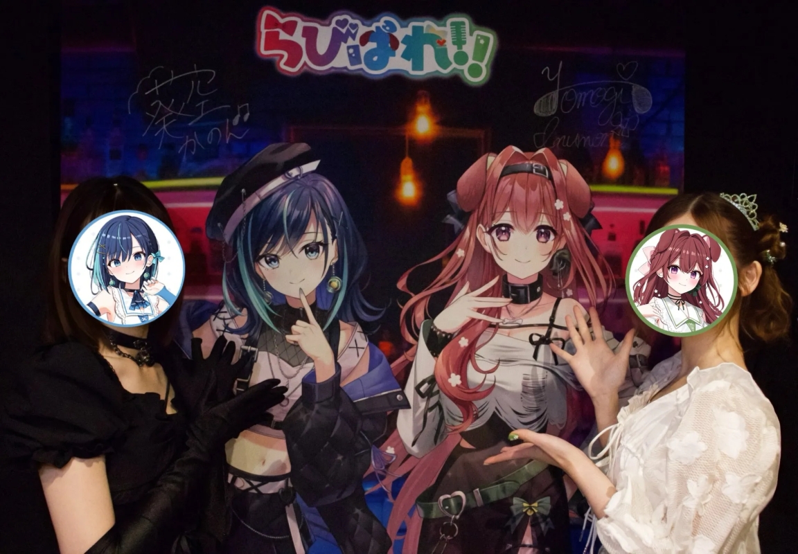 3人の女性が、背景に「らびぱれ!」のロゴと、空澄セナと音街ウナのイラストが描かれたパネルの前でポーズをとっている写真です。女性たちはパネルのキャラクターの顔が描かれた丸いステッカーで顔を隠しています。