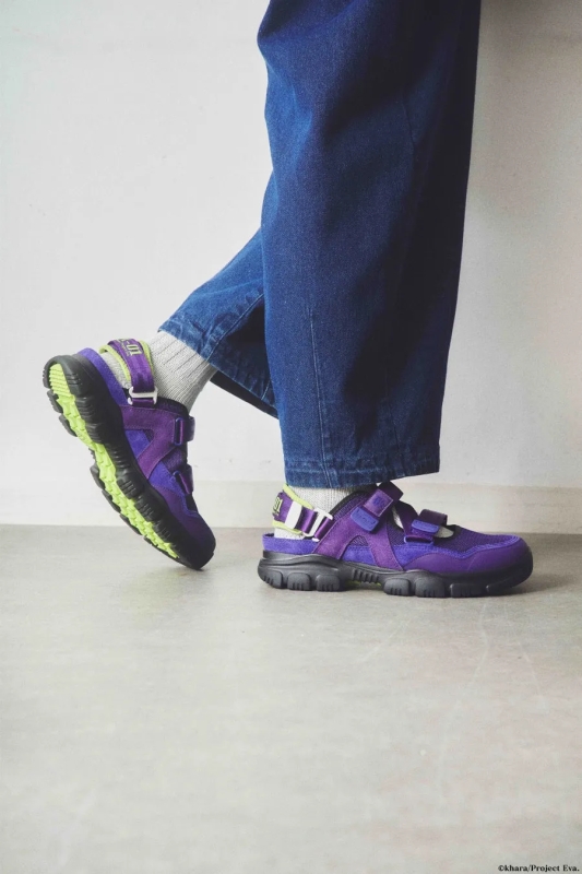 紫色のサンダルを履いた足元の写真です。ジーンズを履いた人が写っています。