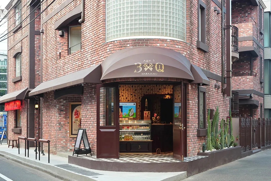 レンガ造りの建物と茶色のひさしが印象的なAge.3. 3Q HARAKUKUの店舗の外観写真。