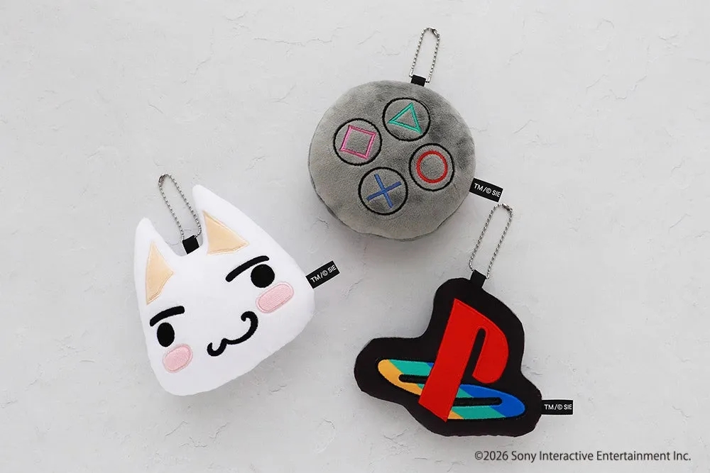 3つのキーホルダーが写っている写真。左上には白い猫の顔のキーホルダー、右上にはゲームコントローラーのキーホルダー、下にはPlayStationのロゴのキーホルダーが写っています。