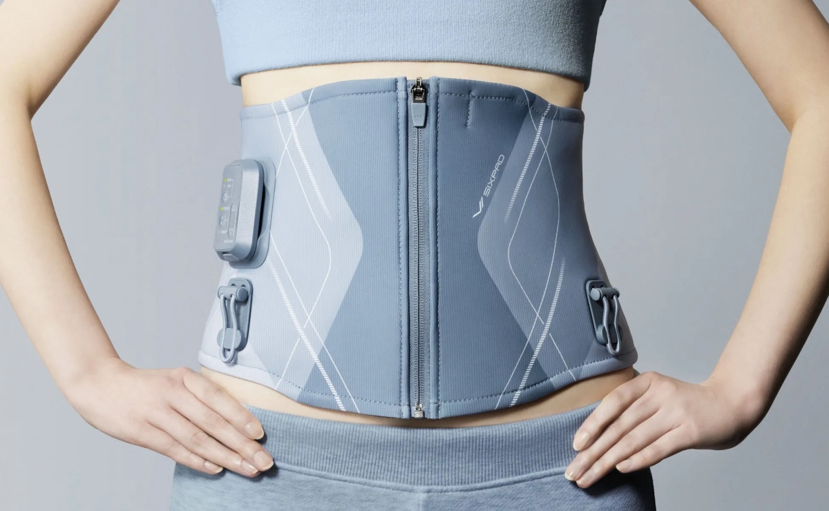 女性が腹部にEMSベルトを装着している様子