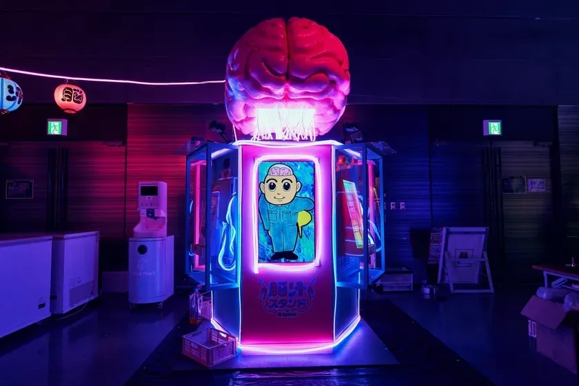ネオンライトで装飾された場所で、脳の形をした奇妙なオブジェが目を引く