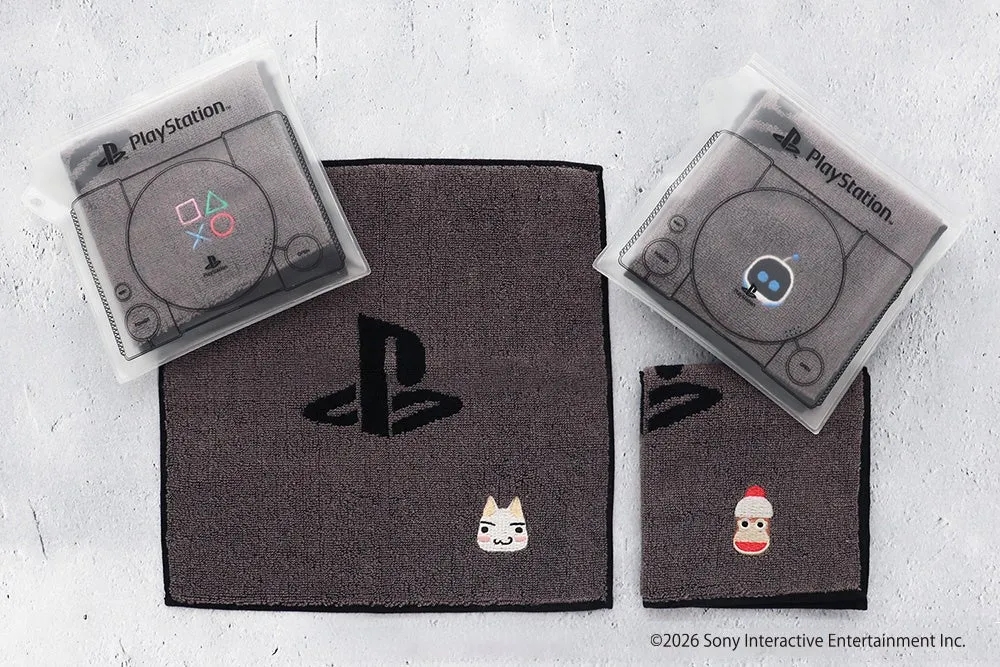PlayStationのロゴやキャラクターがデザインされたタオルセットの写真です。タオルはグレーで、PlayStationのコントローラーやロゴが刺繍されています。また、猫や靴下のキャラクターの刺繍も施されています。