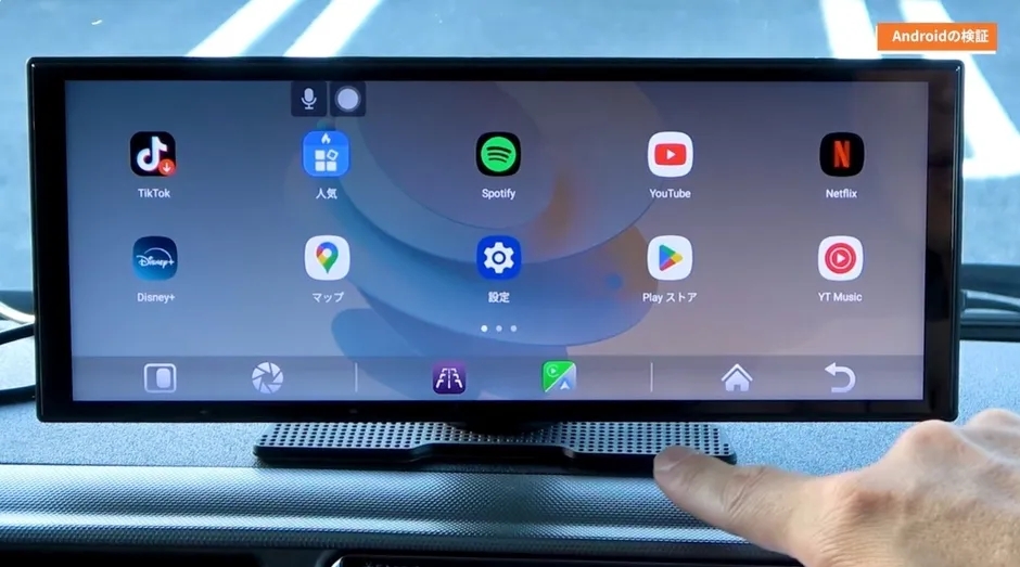 車のダッシュボードに設置されたAndroidデバイスの画面。様々なアプリのアイコンが表示されており、TikTok、Disney+、Spotify、YouTube、Netflixなどが確認できる。