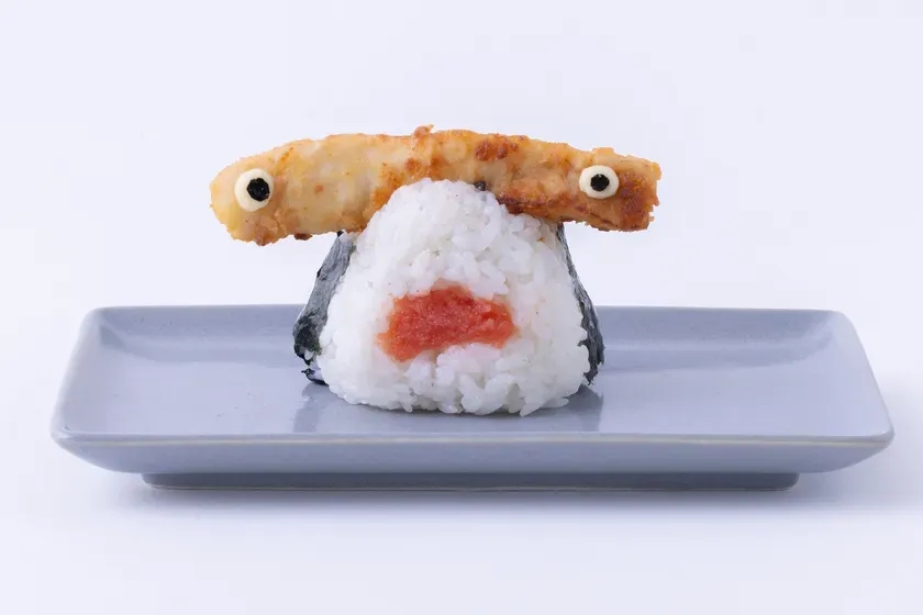 おにぎりがモンスターの顔のように見える写真。おにぎりの上には、揚げ物が目として配置されている。